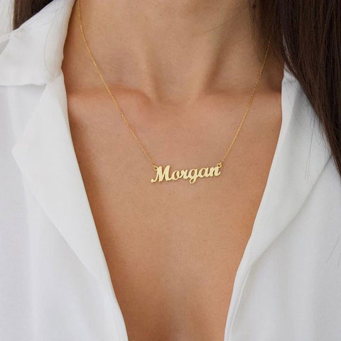 A 14k yellow gold name necklace on a woman's neck